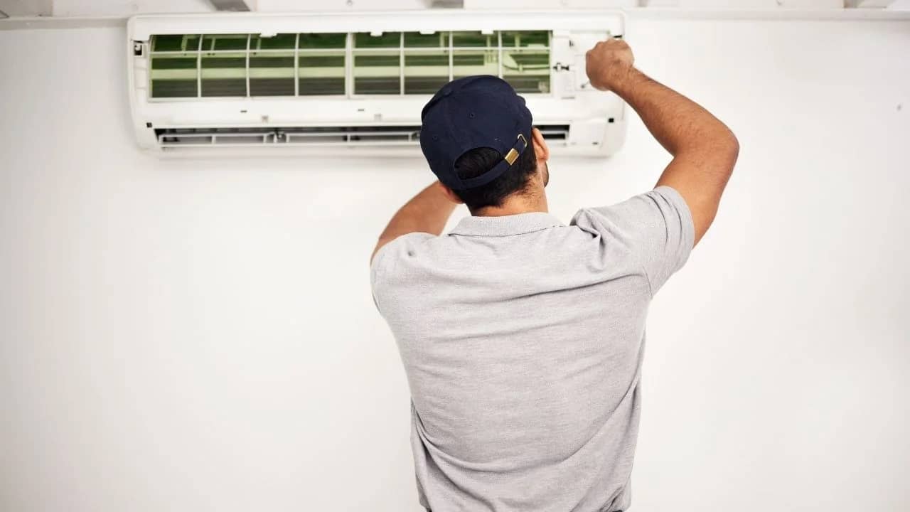 HVAC technician repairing AC unit at Dunrobin riverfront home